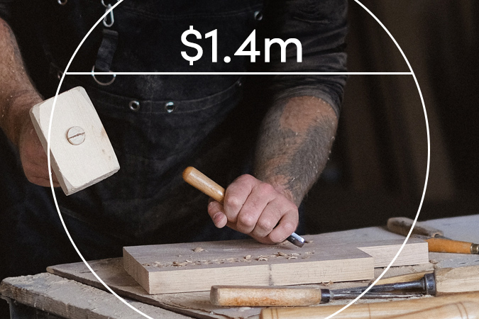 Carpenter with chisel and hammer. Text overlaid: $1.4m